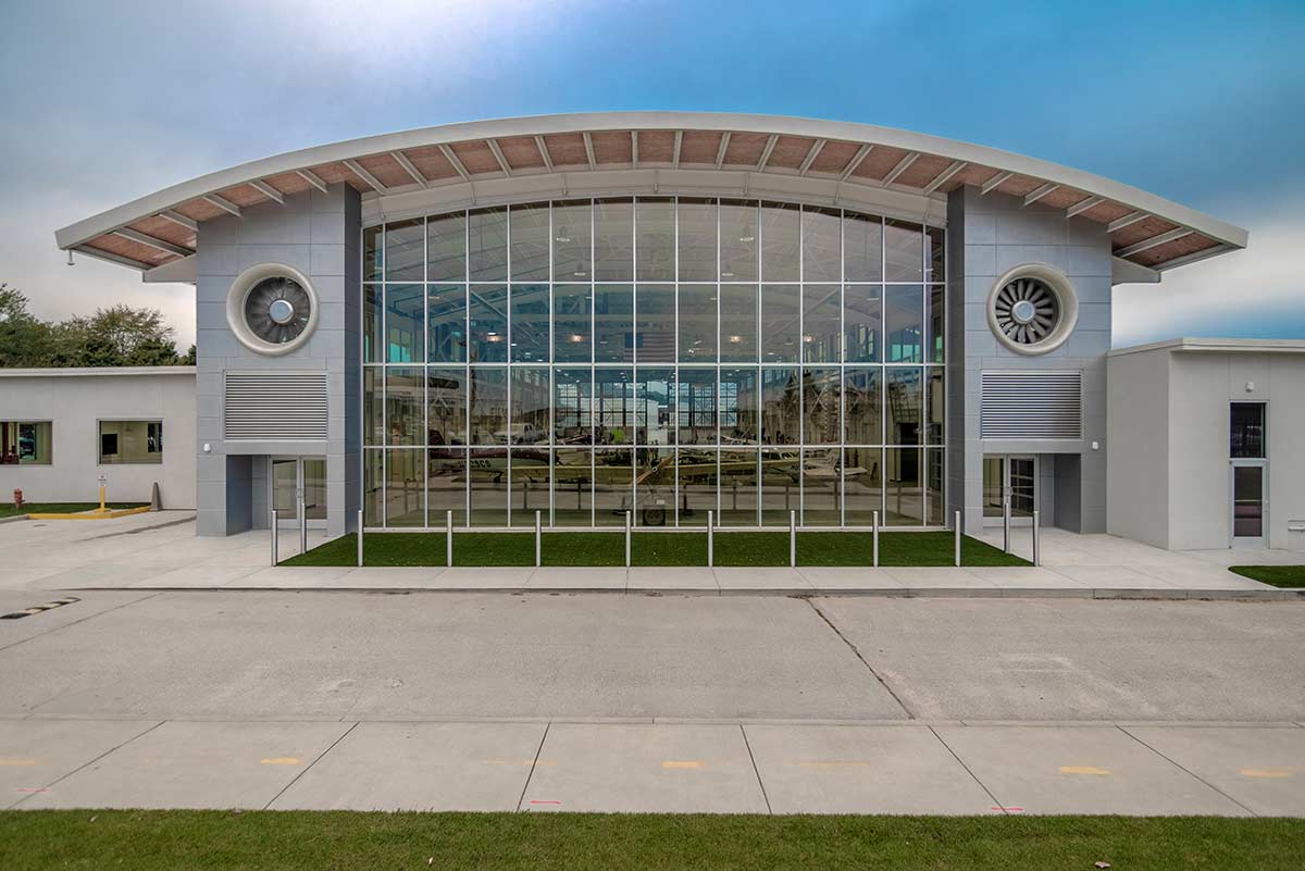 The front of the barrel-roofed Epps Aviation building displays a wall of windows and jet engines, an interesting focal point. The front of the barrel-roofed Epps Aviation building displays a wall of windows and jet engines, an interesting focal point.